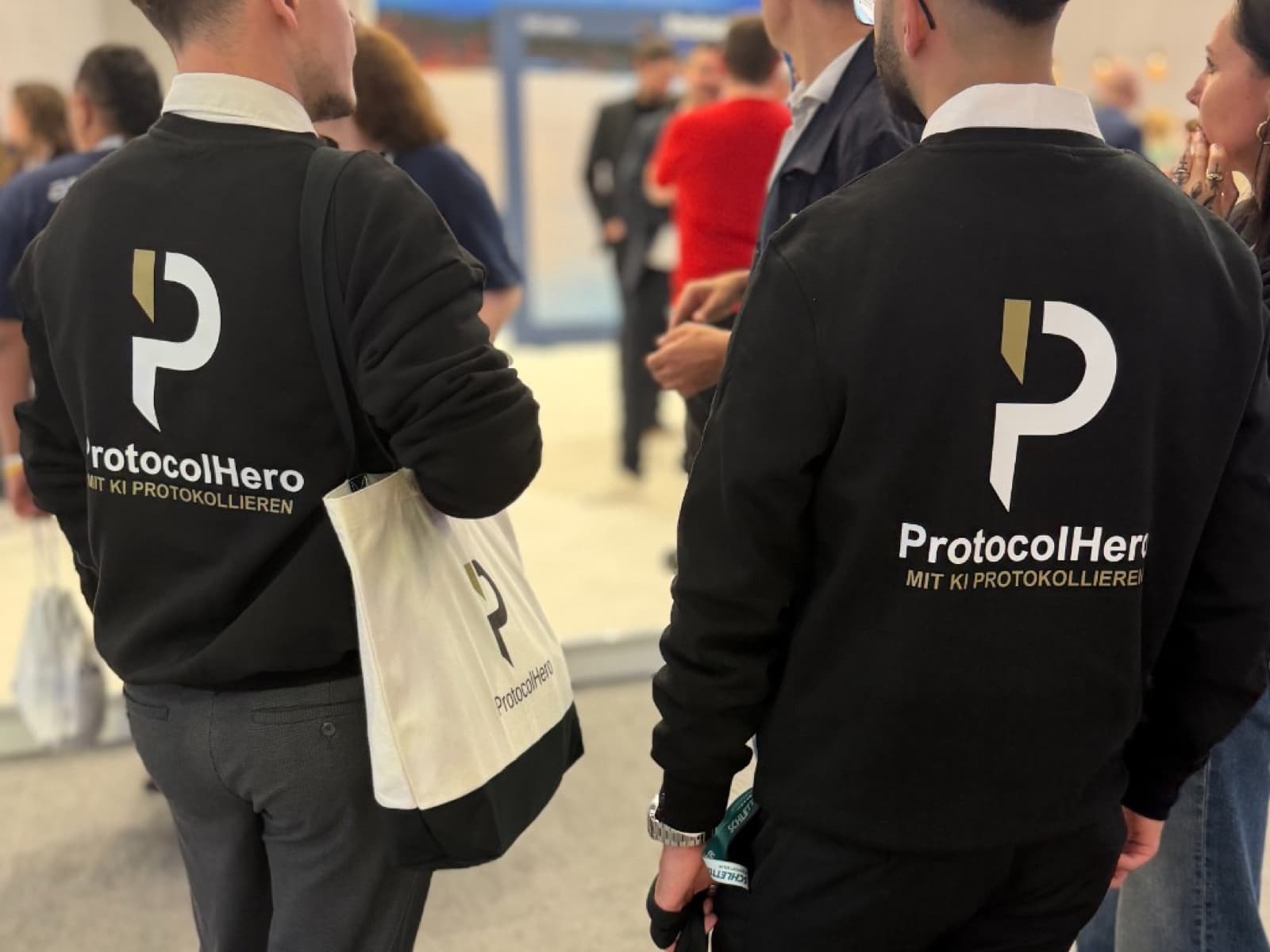 ProtocolHero team from behind at a trade fair in branded hoodies