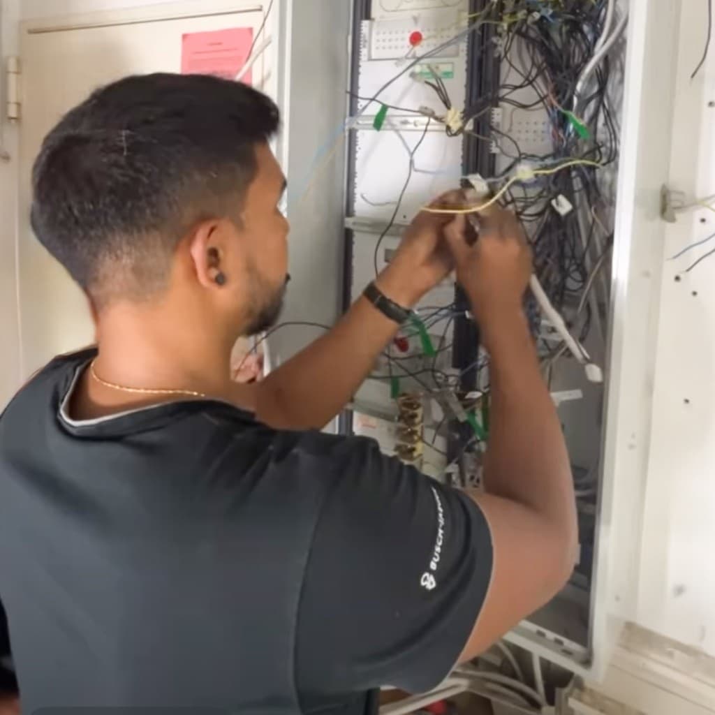 Elektriker arbeitet konzentriert an einem offenen Schaltschrank